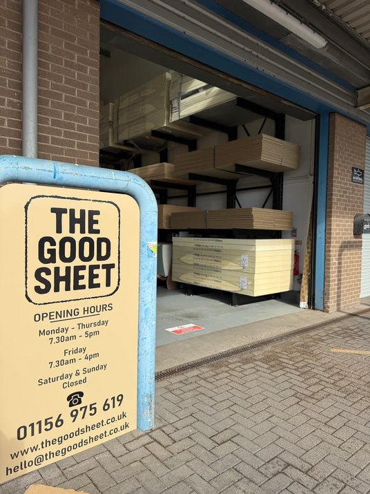 Storefront with 'The Good Sheet' sign and open garage door showing shelves with sheet materials.