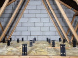Attic insulation with wooden beams and a concrete wall and Loft Leg supports